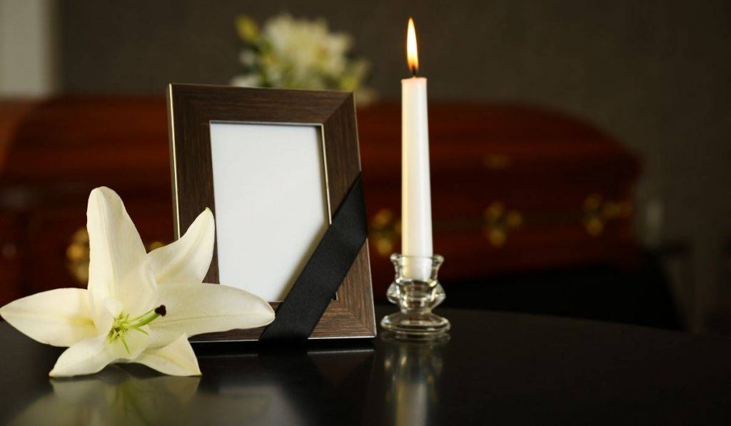 candle, feame and lily on funeral home table